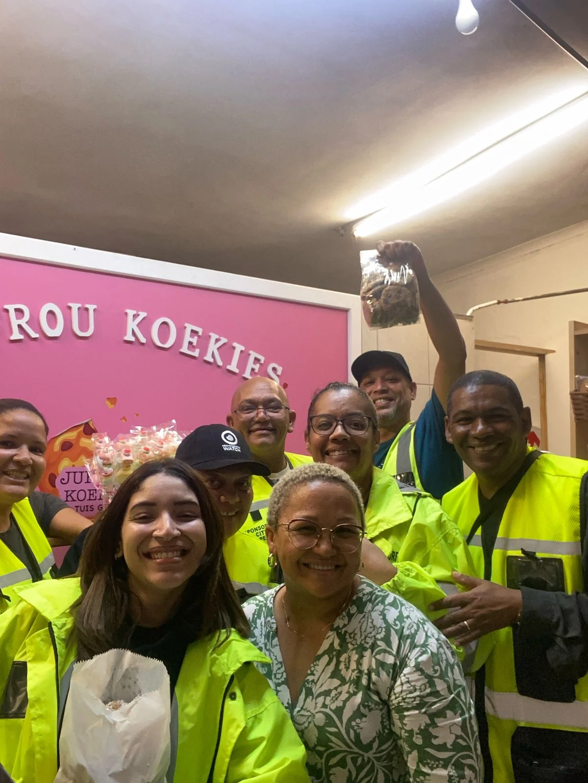 Community participants gathered indoors, with several people wearing high-visibility neighbourhood-watch clothing.